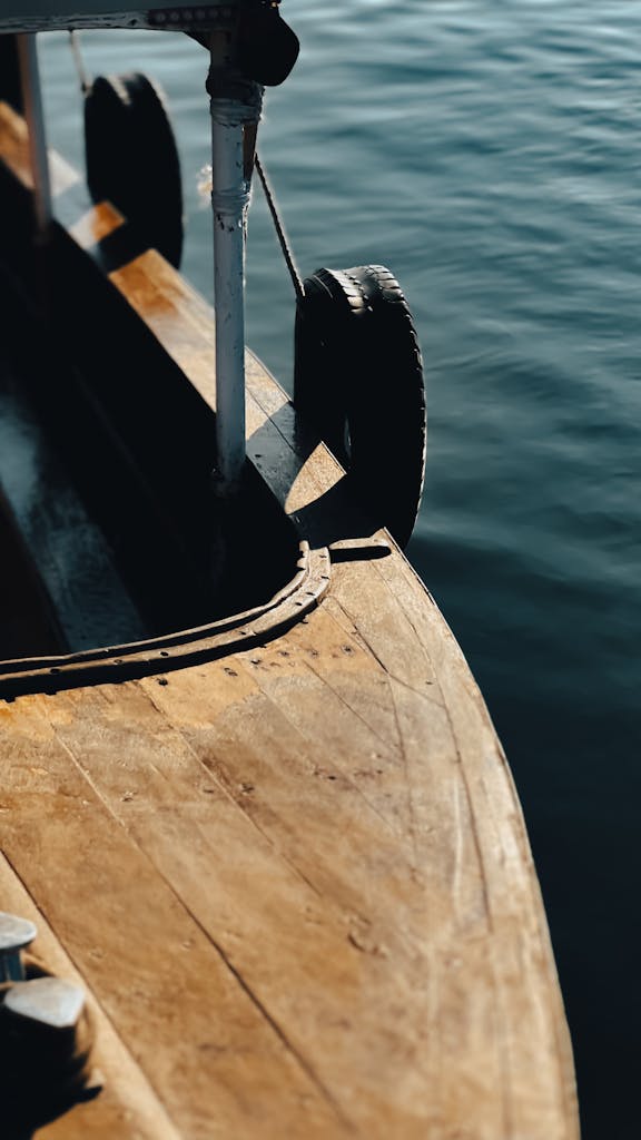 A detailed close-up of a wooden boat floating on the serene waters of Basra, Iraq.